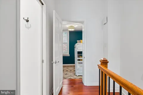 a view of a hallway with wooden floor and staircase