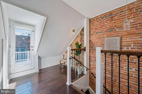 a view of staircase with wooden floor and white walls