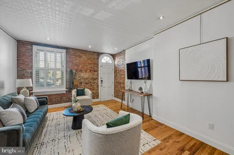 a living room with furniture a flat screen tv and a large window