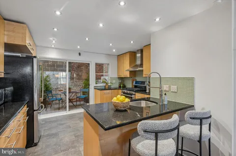 a kitchen with a table chairs sink and refrigerator