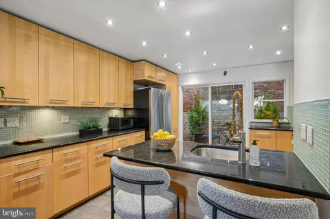 a kitchen with stainless steel appliances granite countertop sink stove and cabinets