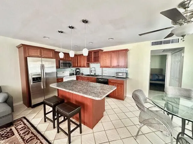 a kitchen with stainless steel appliances granite countertop a refrigerator and a stove top oven