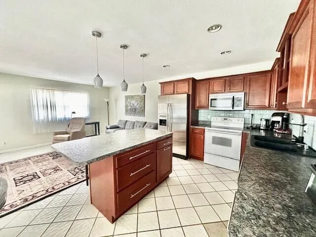 a kitchen with stainless steel appliances granite countertop a stove top oven a sink a counter top space and cabinets