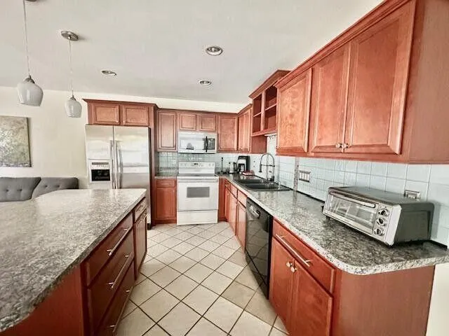 a kitchen with stainless steel appliances granite countertop a sink stove cabinets and granite counter tops