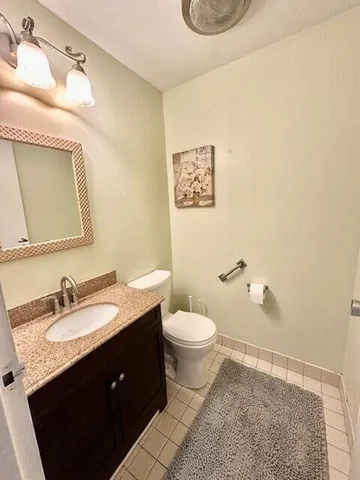 a bathroom with a sink vanity mirror and toilet