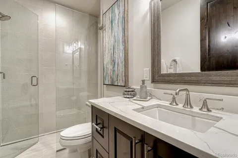 a bathroom with a double vanity sink toilet and a mirror