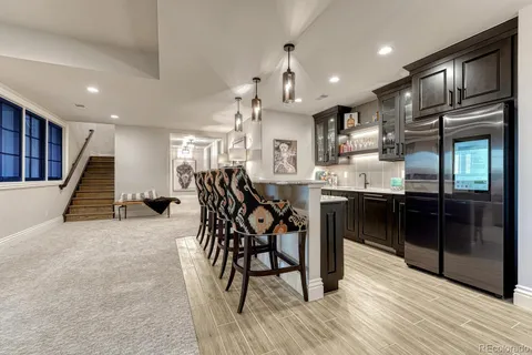 a kitchen with stainless steel appliances kitchen island granite countertop a table chairs sink and cabinets