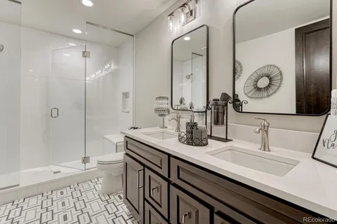 a bathroom with a double vanity sink mirror and shower