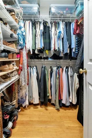 a view of walk in closet with clothes and shoes