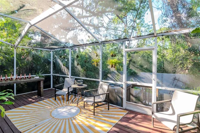 a view of a patio with a dining table and chairs with wooden floor and fence