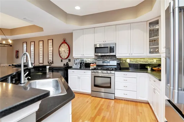 a kitchen with stainless steel appliances granite countertop a stove a sink and a microwave