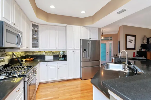 a kitchen with stainless steel appliances granite countertop a stove refrigerator and cabinets
