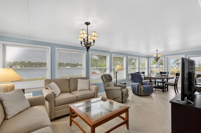 a living room with furniture a flat screen tv and a large window