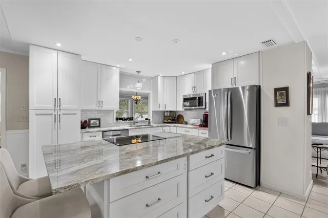 a kitchen with stainless steel appliances granite countertop a refrigerator and a stove top oven