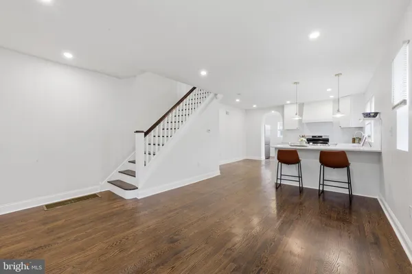 a room with stainless steel appliances kitchen island a sink a stove a dining table and chairs