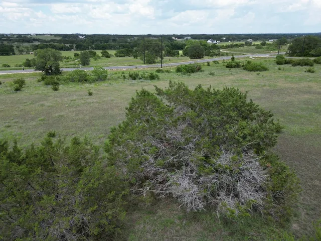 an aerial view of field with trees