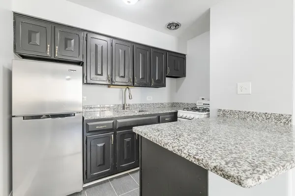 a kitchen with a sink refrigerator and cabinets