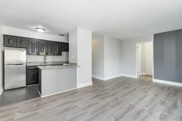 a kitchen with granite countertop a refrigerator and a stove top oven