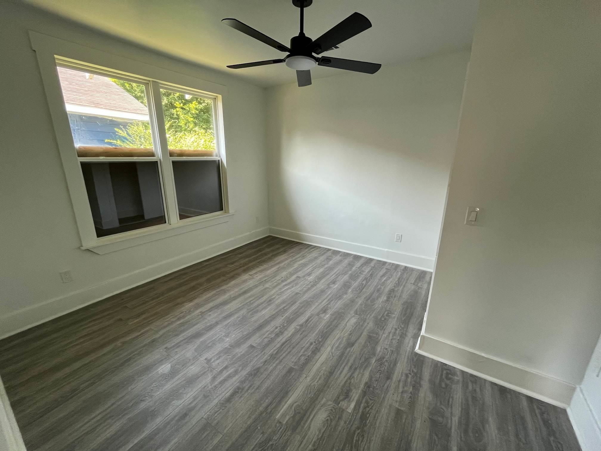 1131 Rozelle Street Memphis, TN 38106 - Photo 17 of 19 an empty room with wooden floor fan and windows
