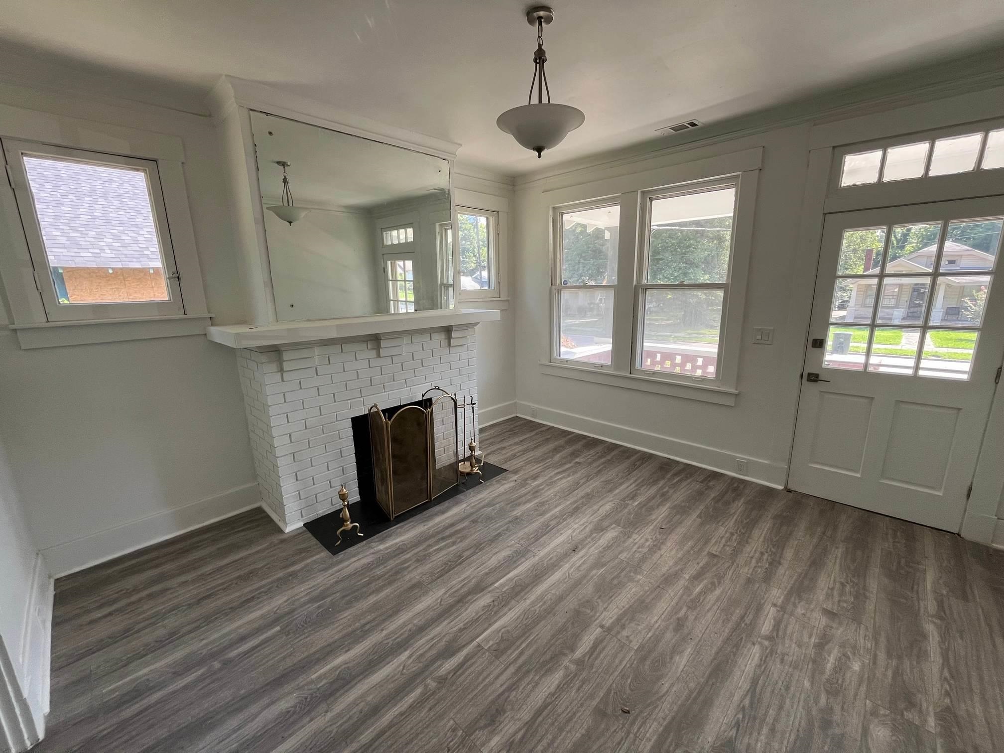 1131 Rozelle Street Memphis, TN 38106 - Photo 5 of 19 a view of empty room with wooden floor and fireplace