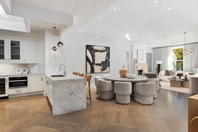 a living room with furniture a fireplace and a chandelier