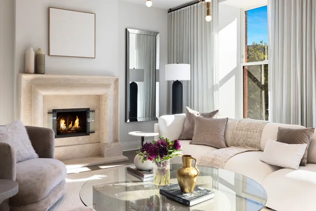 a living room with fireplace furniture and a large window