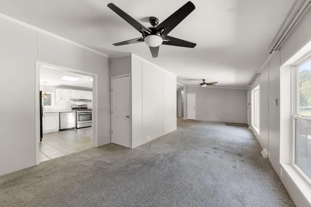 a view of an empty room and kitchen view