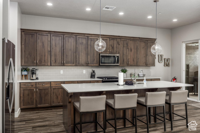 2600 Ocotillo Way, Unit 34 Santa Clara, UT 84765 - Photo 3 of 43 Kitchen featuring appliances with stainless steel finishes, recessed lighting, hanging light fixtures, a center island with sink, and backsplash