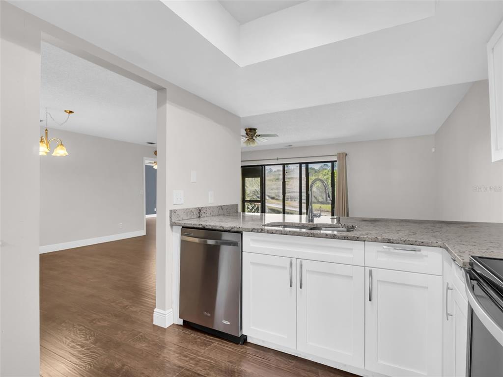 1801 East Lake Road South, Unit 20C Palm Harbor, FL 34685 - Photo 13 of 56 a kitchen with granite countertop white cabinets and a stove