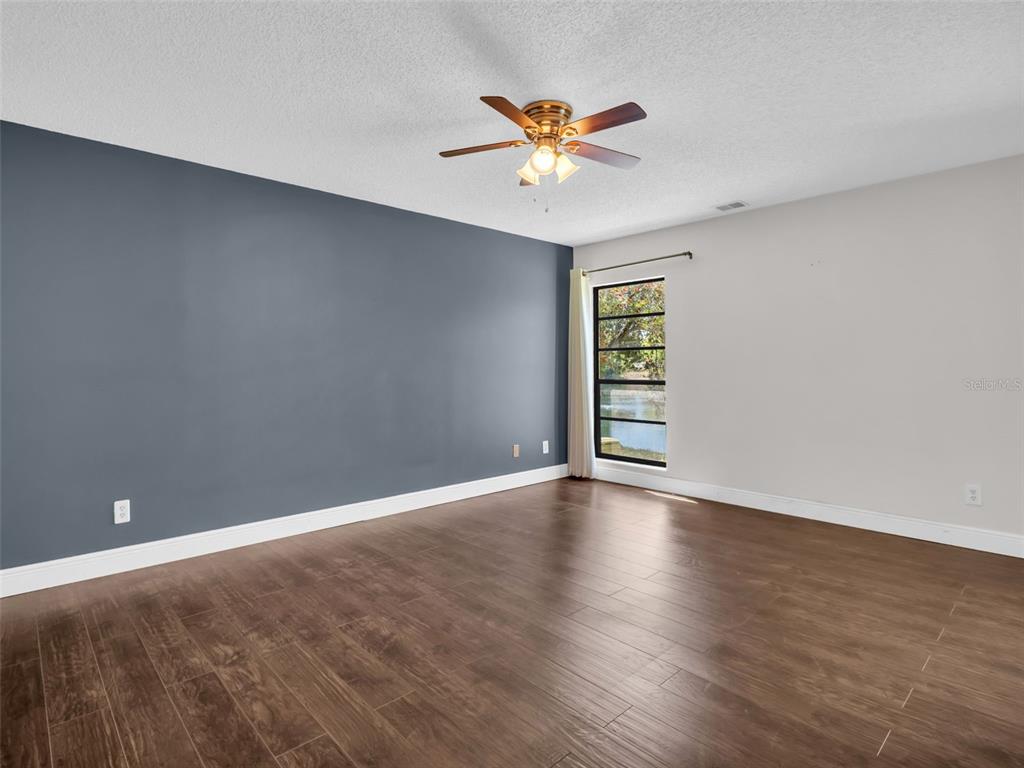 1801 East Lake Road South, Unit 20C Palm Harbor, FL 34685 - Photo 25 of 56 a view of an empty room with a window and wooden floor