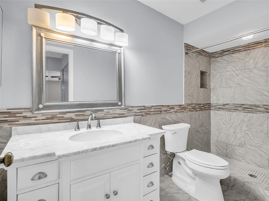 1801 East Lake Road South, Unit 20C Palm Harbor, FL 34685 - Photo 26 of 56 a bathroom with a toilet sink and mirror