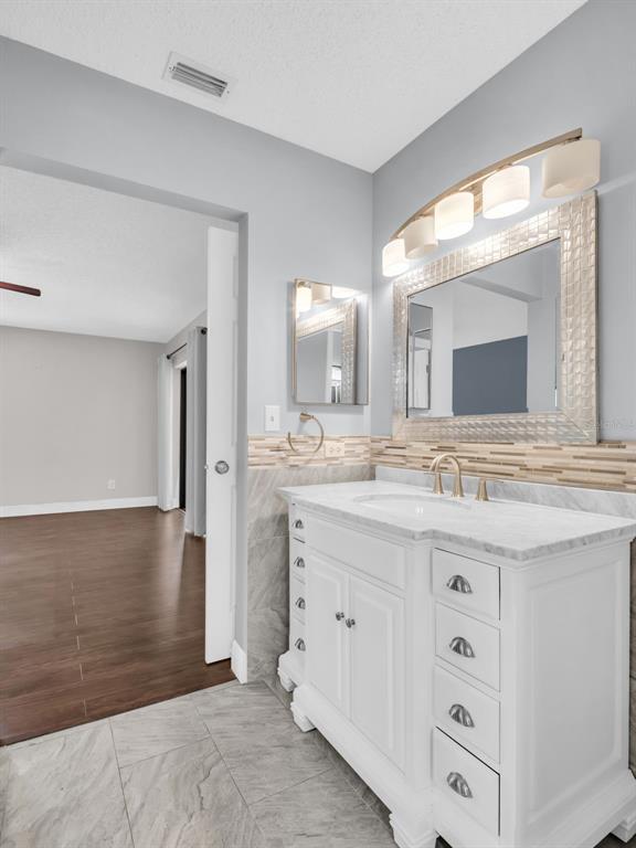 1801 East Lake Road South, Unit 20C Palm Harbor, FL 34685 - Photo 31 of 56 a bathroom with a granite countertop sink mirror and vanity