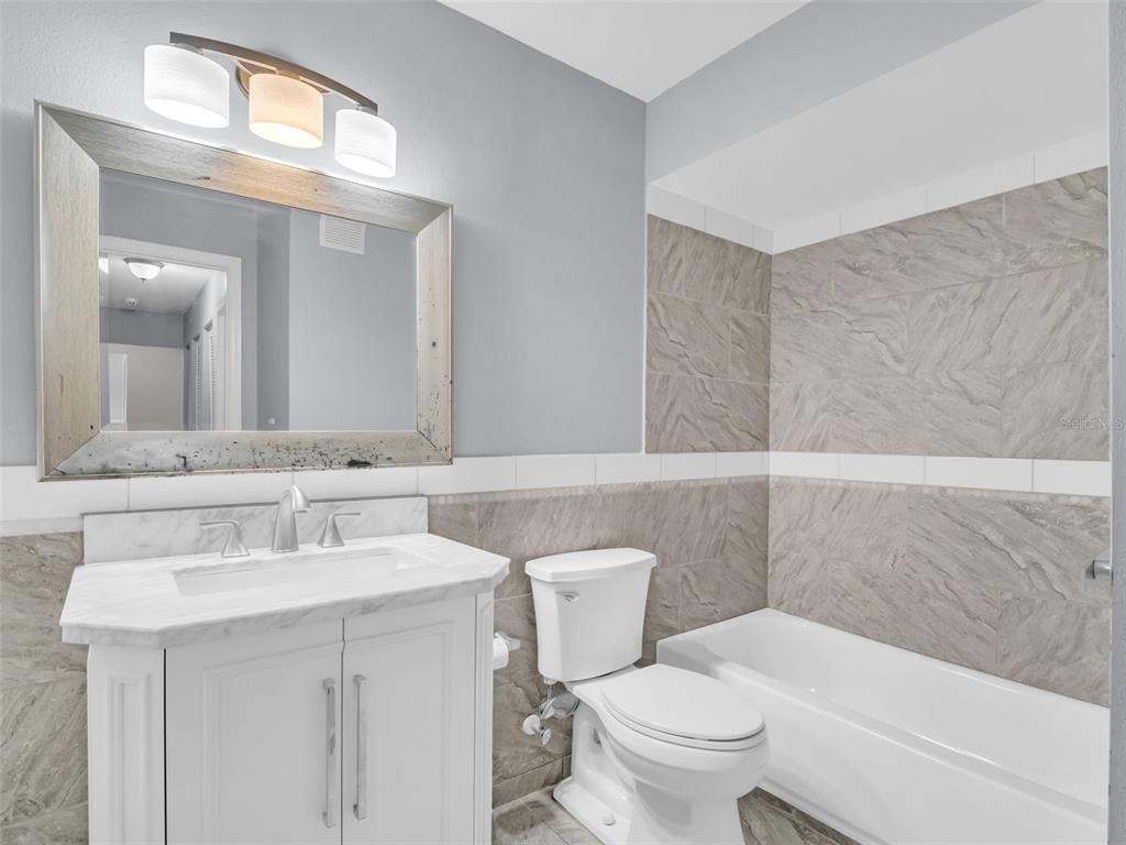 1801 East Lake Road South, Unit 20C Palm Harbor, FL 34685 - Photo 45 of 56 a bathroom with a sink toilet and a mirror