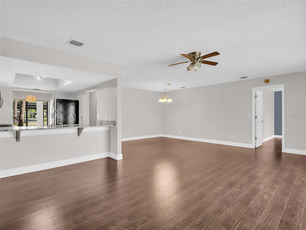 1801 East Lake Road South, Unit 20C Palm Harbor, FL 34685 - Photo 10 of 56 a view of a livingroom with a ceiling fan and hardwood floor