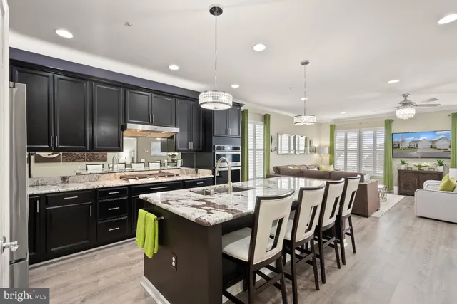 a kitchen with stainless steel appliances kitchen island granite countertop a stove refrigerator and cabinets