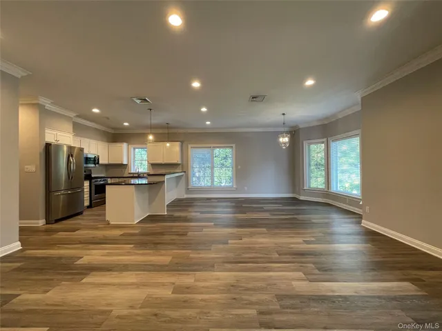a view of a white house with a yard and sitting area