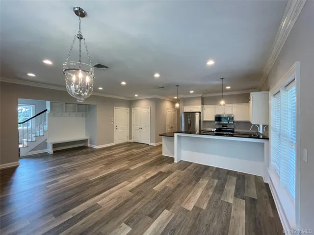 a view of kitchen with white cabinets and stainless steel appliances