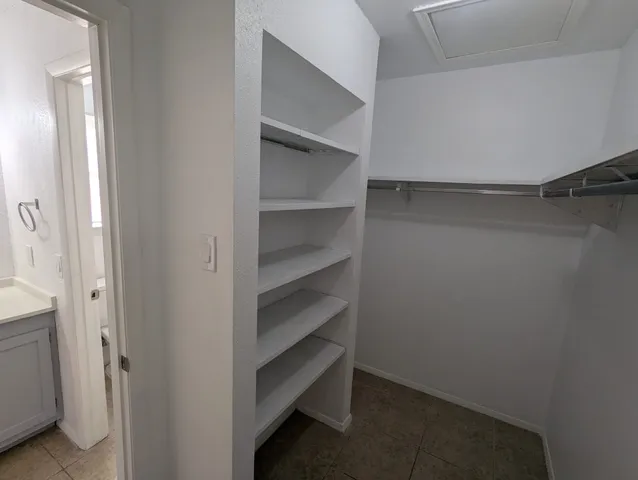 a view of walk in closet with empty racks