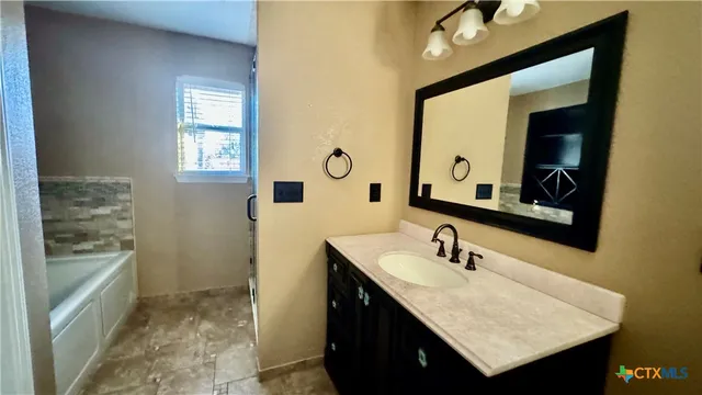 a bathroom with a sink vanity granite and a mirror