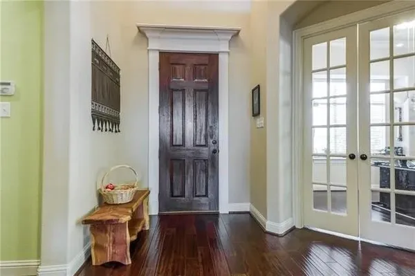 a view of a hallway with wooden floor and entryway