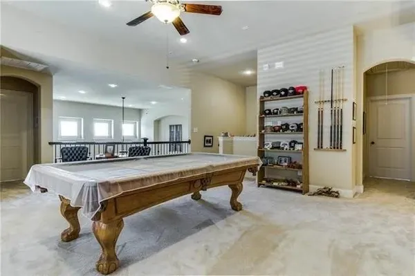 a room with pool table and ceiling fan
