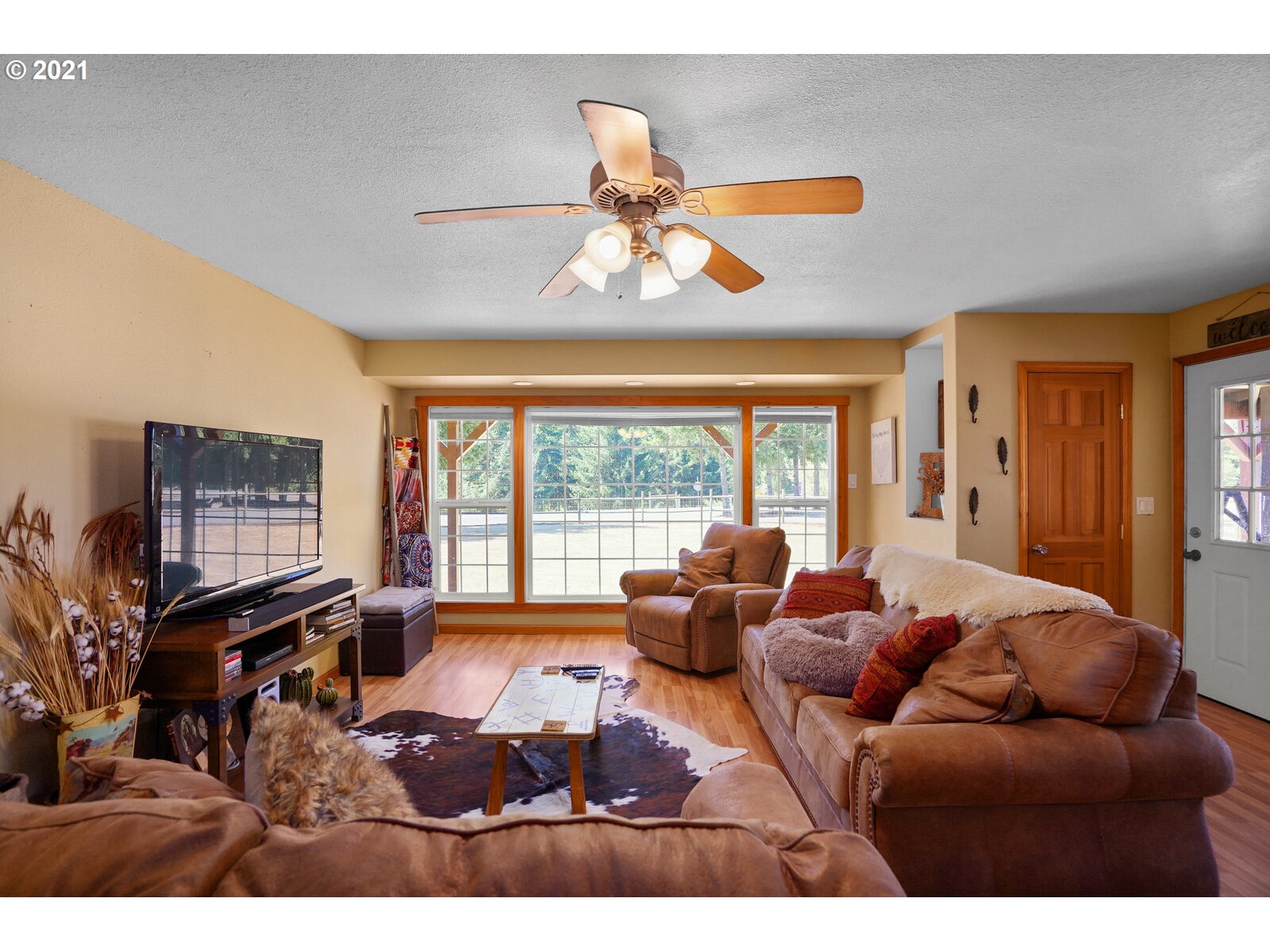 9310 Harmony Road Sheridan, OR 97378 - Photo 6 of 32 a living room with furniture a flat screen tv and a large window
