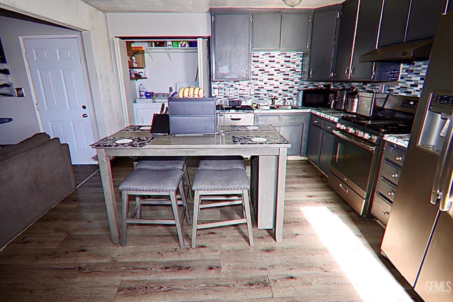 Undisclosed Address Ridgecrest, CA 93555 - Photo 2 of 8 a kitchen with a table chairs stove and cabinets