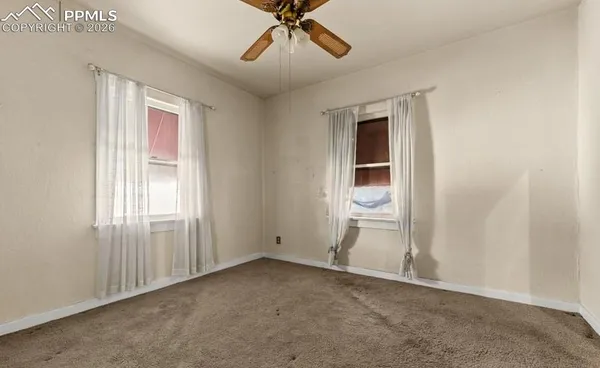 an empty room with closet and windows