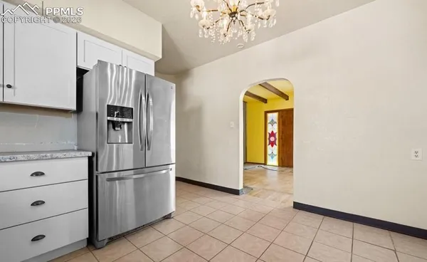 a view of a refrigerator in kitchen and a window