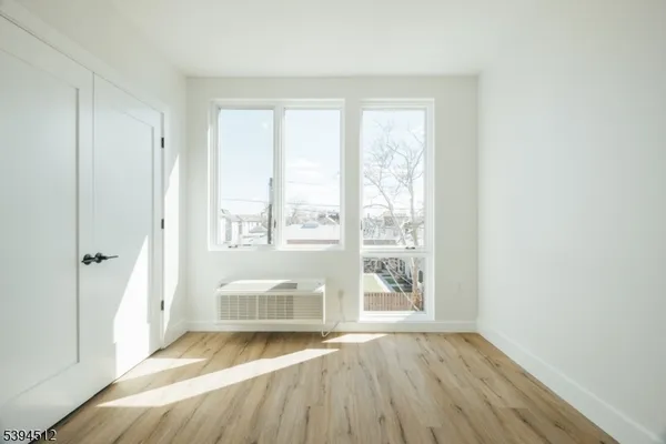 a view of room with window and wooden floor