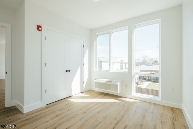 67 Dr Martin Luther King Jr Boulevard, Unit 204 Newark, NJ 07104 - Photo 14 of 27 a view of an empty room with wooden floor and a window