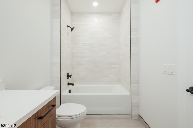 67 Dr Martin Luther King Jr Boulevard, Unit 204 Newark, NJ 07104 - Photo 18 of 27 a bathroom with a granite countertop bathtub shower sink vanity and toilet