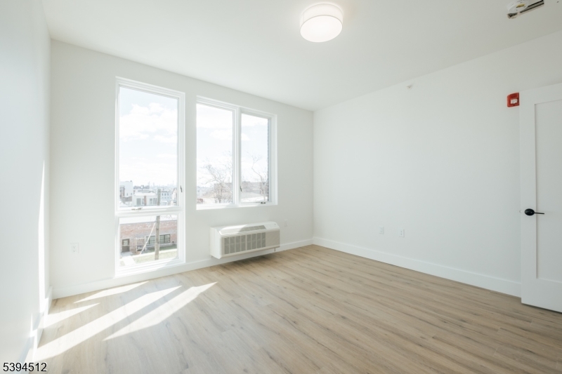 67 Dr Martin Luther King Jr Boulevard, Unit 204 Newark, NJ 07104 - Photo 19 of 27 a view of an empty room with wooden floor and a window