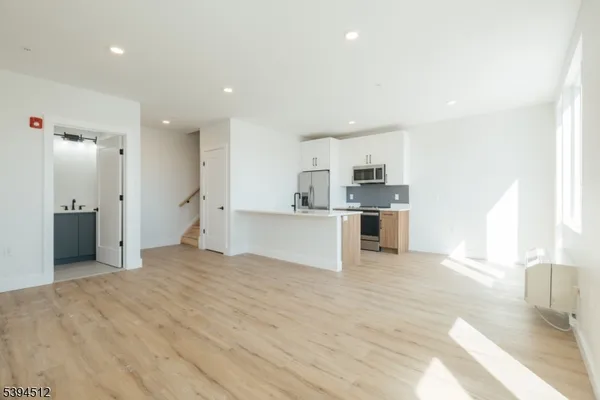 a view of a kitchen with a sink and dishwasher a refrigerator with wooden floor